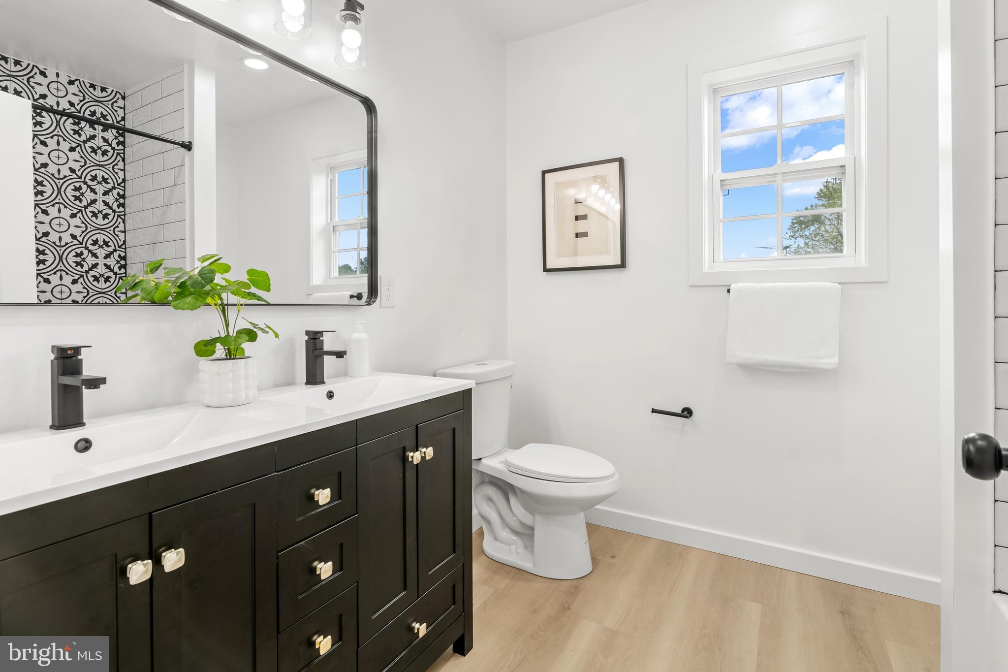 7817 Liberty Road Windsor Mill, MD 21244 - Photo 37 of 50 a bathroom with a double vanity sink toilet and a mirror