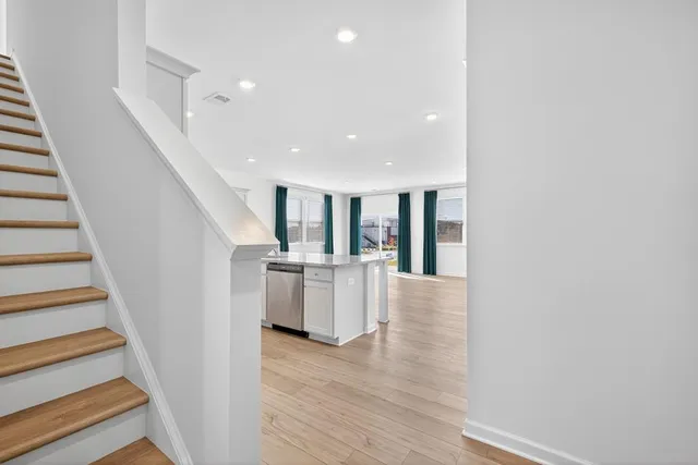 a view of entryway with kitchen and wooden floor