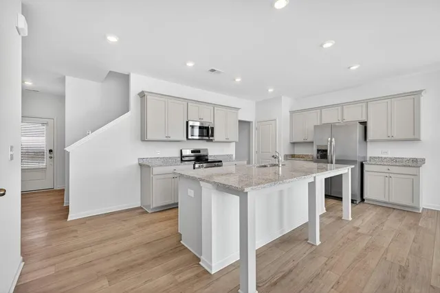 a kitchen with white cabinets stainless steel appliances and sink