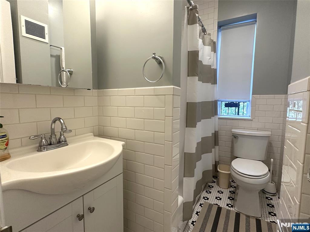 275 Engle Street, Unit J4 Englewood, NJ 07631 - Photo 11 of 12 a bathroom with a sink a toilet and a mirror