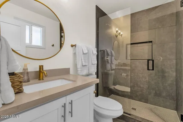 a bathroom with a sink a toilet and shower