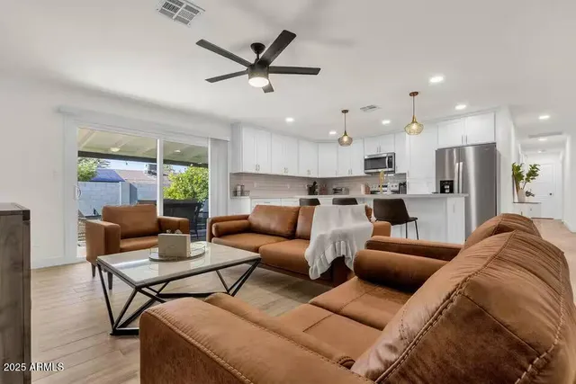 a living room with furniture and a view of kitchen