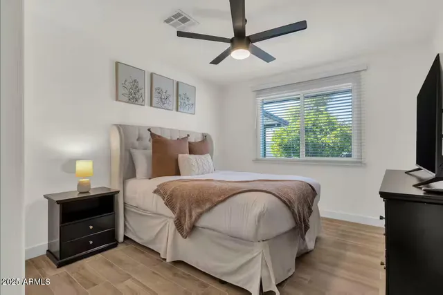 a bedroom with a bed and a flat tv screen on a dresser
