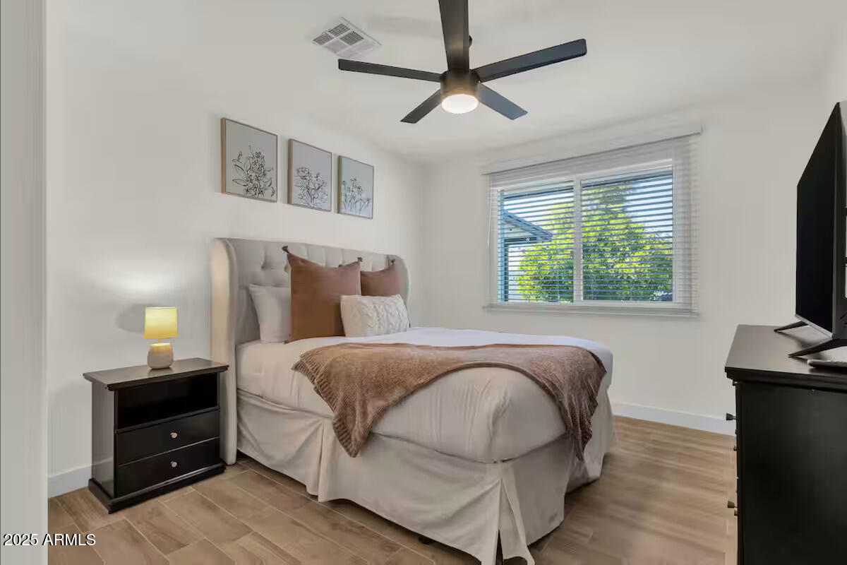 2452 East Manhatton Drive Tempe, AZ 85282 - Photo 6 of 25 a bedroom with a bed and a flat tv screen on a dresser