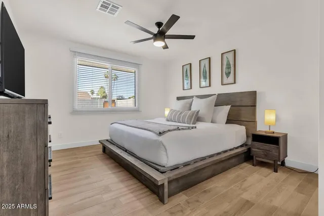 a bedroom with a bed and a ceiling fan