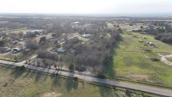 an aerial view of residential houses with outdoor space and lake view