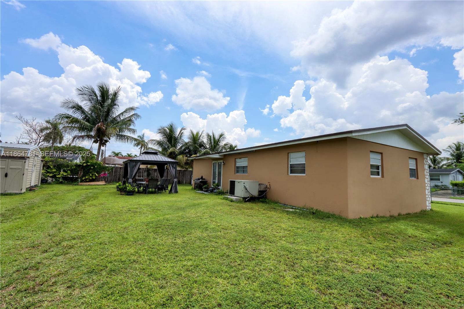30211 Southwest 158th Road Homestead, FL 33033 - Photo 12 of 47 a backyard of a house with table and chairs plants and large tree