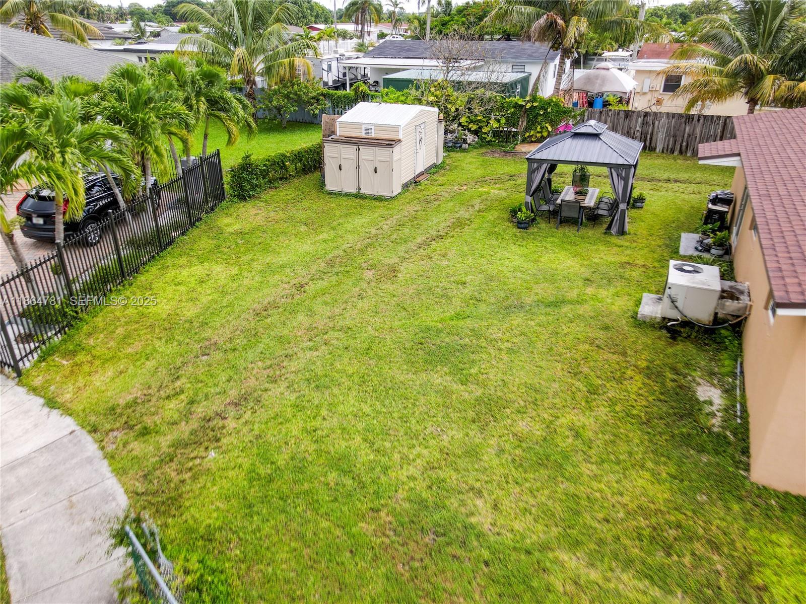 30211 Southwest 158th Road Homestead, FL 33033 - Photo 14 of 47 a backyard of a house with table and chairs