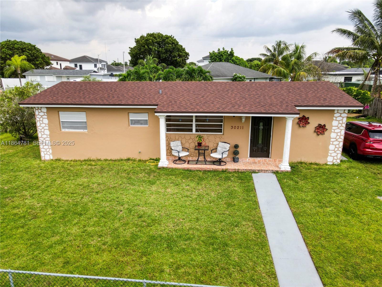 30211 Southwest 158th Road Homestead, FL 33033 - Photo 2 of 47 a front view of house with yard and green space
