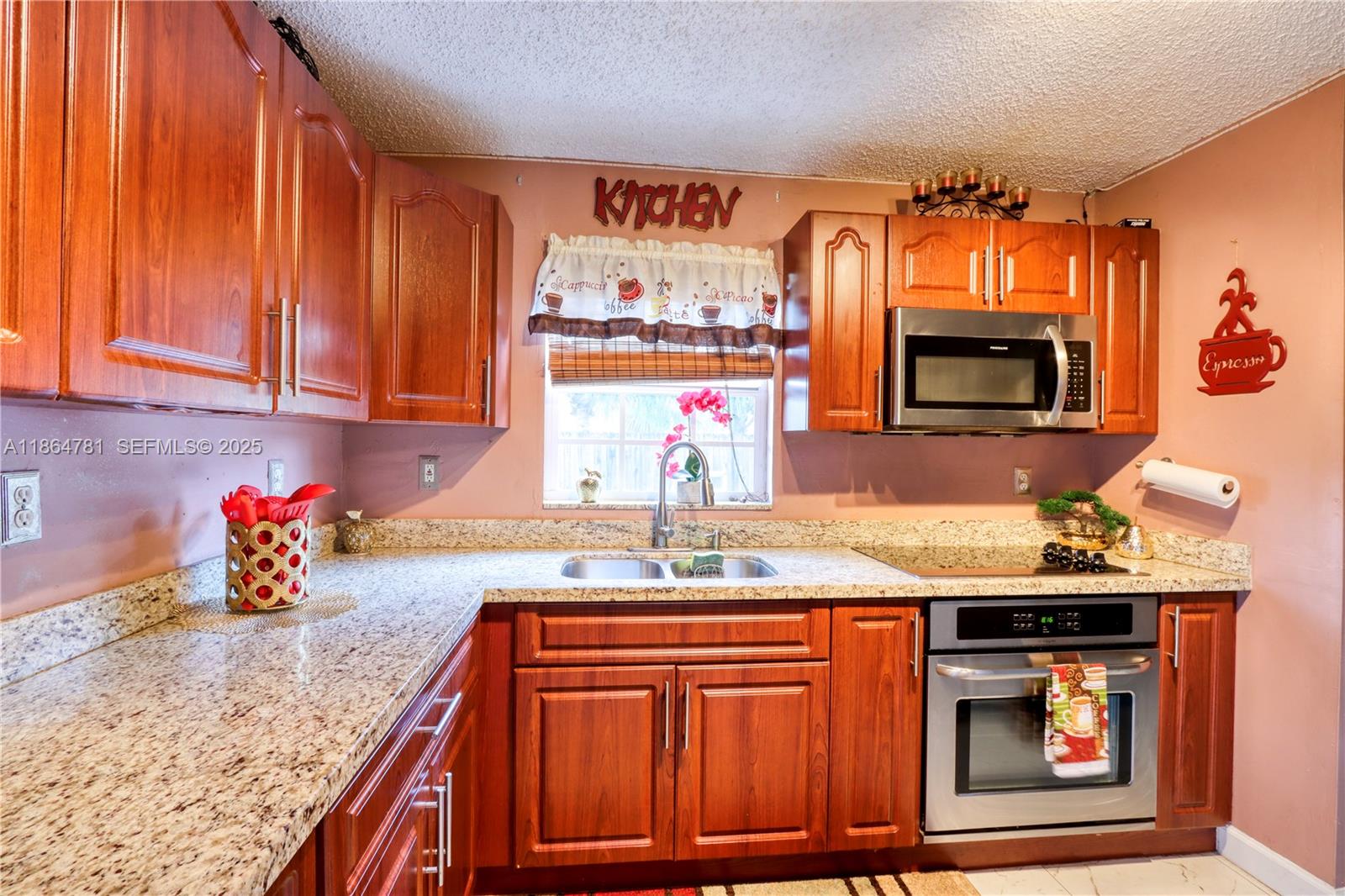 30211 Southwest 158th Road Homestead, FL 33033 - Photo 34 of 47 a kitchen with stainless steel appliances granite countertop a sink dishwasher and microwave with wooden cabinets