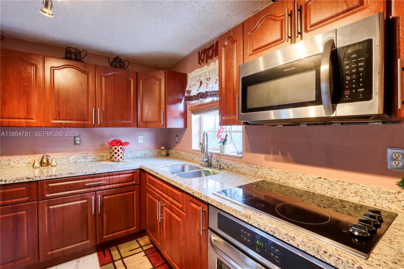 30211 Southwest 158th Road Homestead, FL 33033 - Photo 36 of 47 a kitchen with stainless steel appliances a stove a sink and a microwave