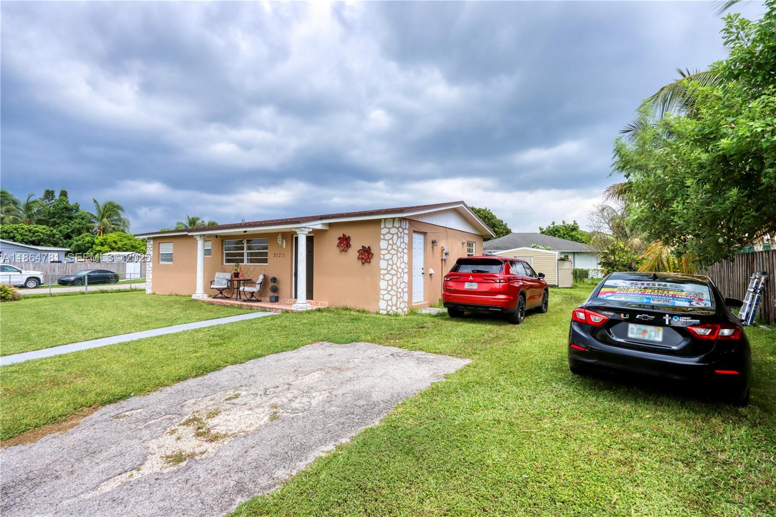 30211 Southwest 158th Road Homestead, FL 33033 - Photo 6 of 47 a front view of a house with a garden