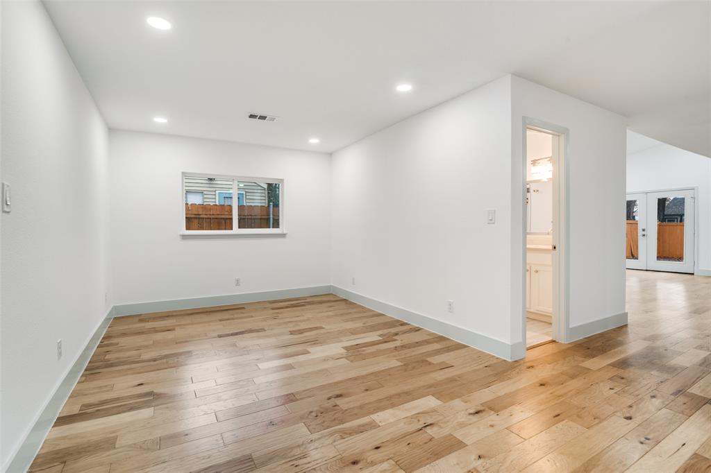 8722 Angora Street Dallas, TX 75218 - Photo 12 of 26 an empty room with wooden floor and windows