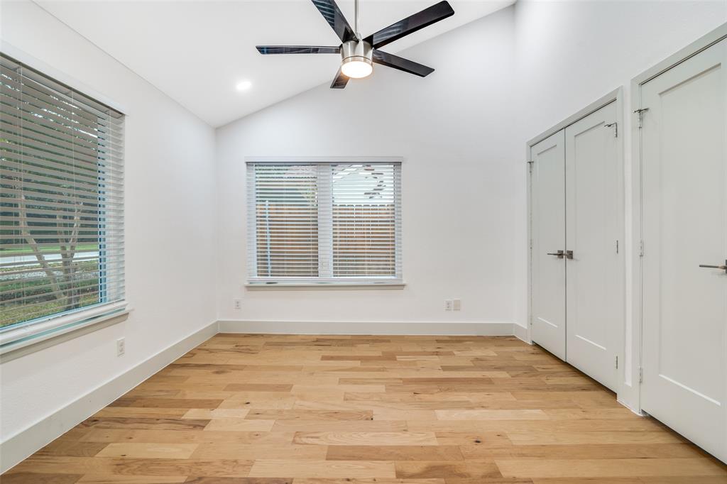 8722 Angora Street Dallas, TX 75218 - Photo 13 of 26 a view of an empty room with wooden floor and a window