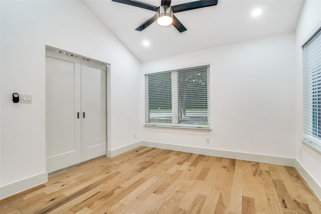 8722 Angora Street Dallas, TX 75218 - Photo 14 of 26 a view of an empty room with a window and wooden floor