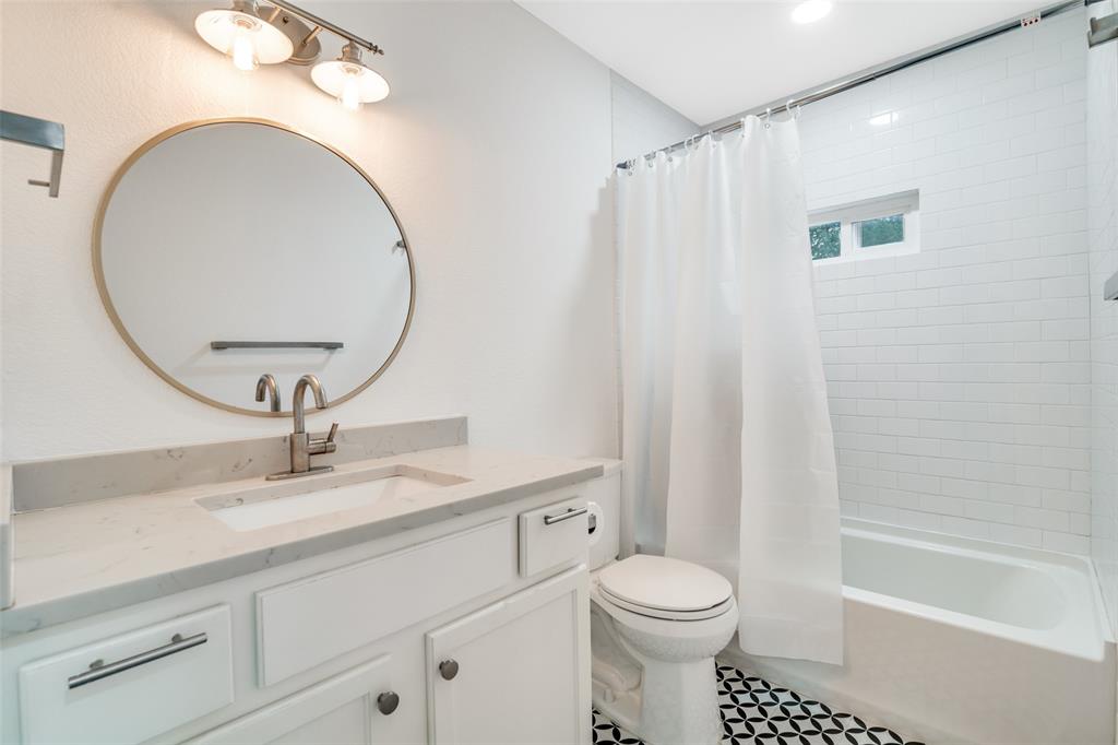 8722 Angora Street Dallas, TX 75218 - Photo 23 of 26 a bathroom with a sink a toilet and a mirror