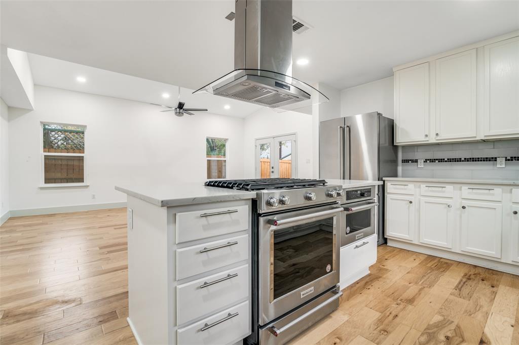 8722 Angora Street Dallas, TX 75218 - Photo 9 of 26 a kitchen with stainless steel appliances a stove and white cabinets