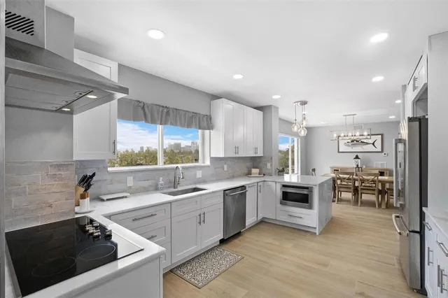 a kitchen with stainless steel appliances white cabinets and a stove top oven