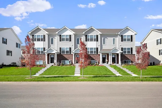 a view of a white house with a yard and plants