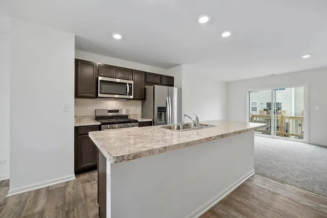 a large kitchen with kitchen island a sink stove and refrigerator
