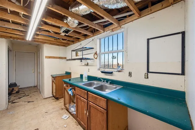 a kitchen that has a sink a stove and a refrigerator