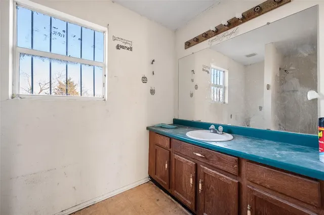 a bathroom with a granite countertop sink and mirror