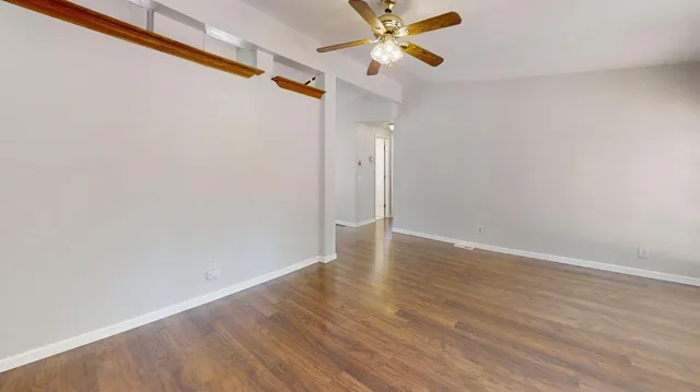 a view of a room with wooden floor and fan