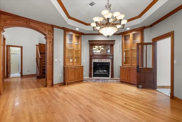 an empty room with windows and chandelier