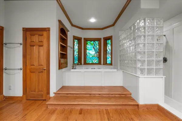 a view of a hallway with wooden floor and staircase