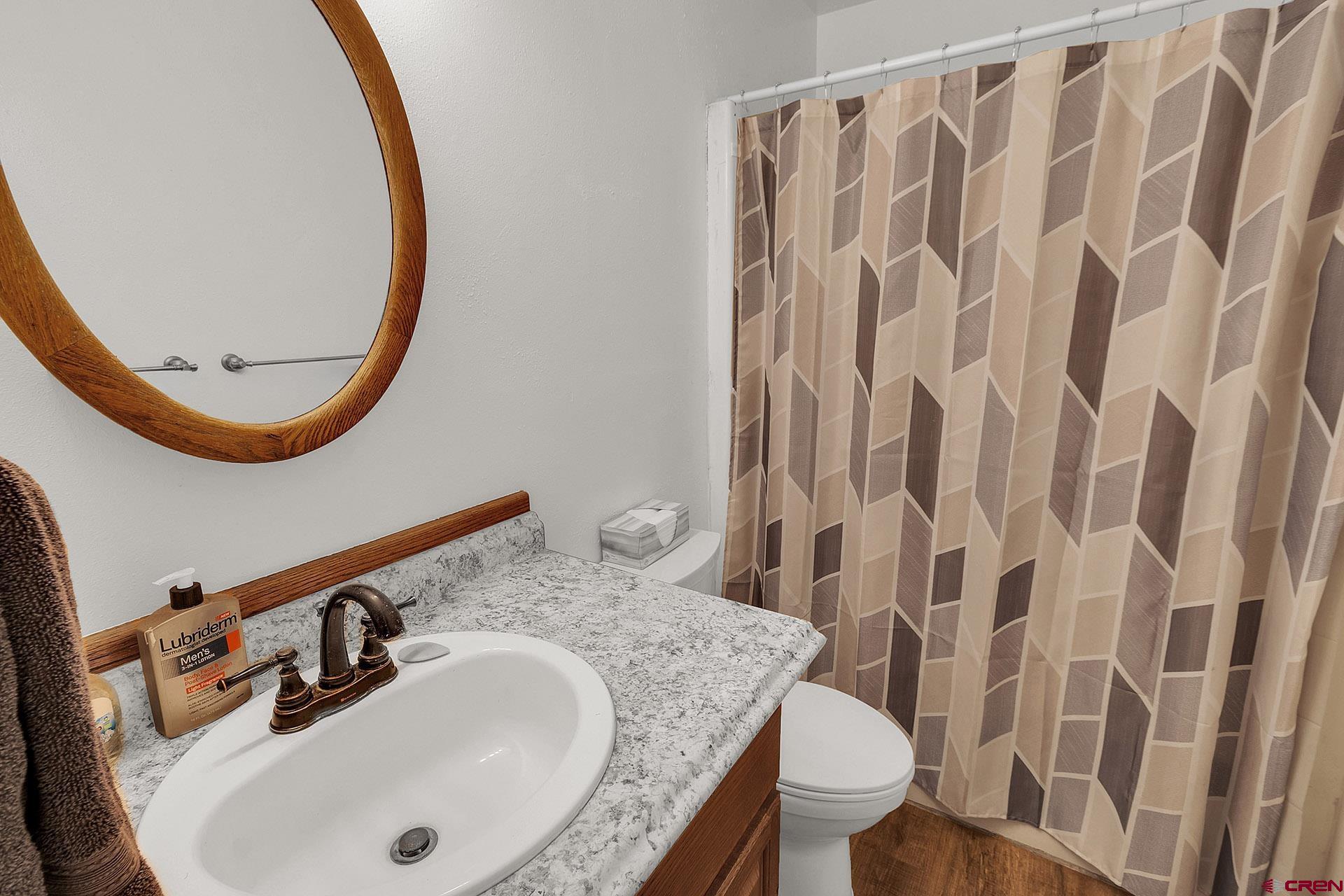 1011 Ray Avenue Delta, CO 81416 - Photo 16 of 26 a bathroom with a granite countertop sink and a mirror