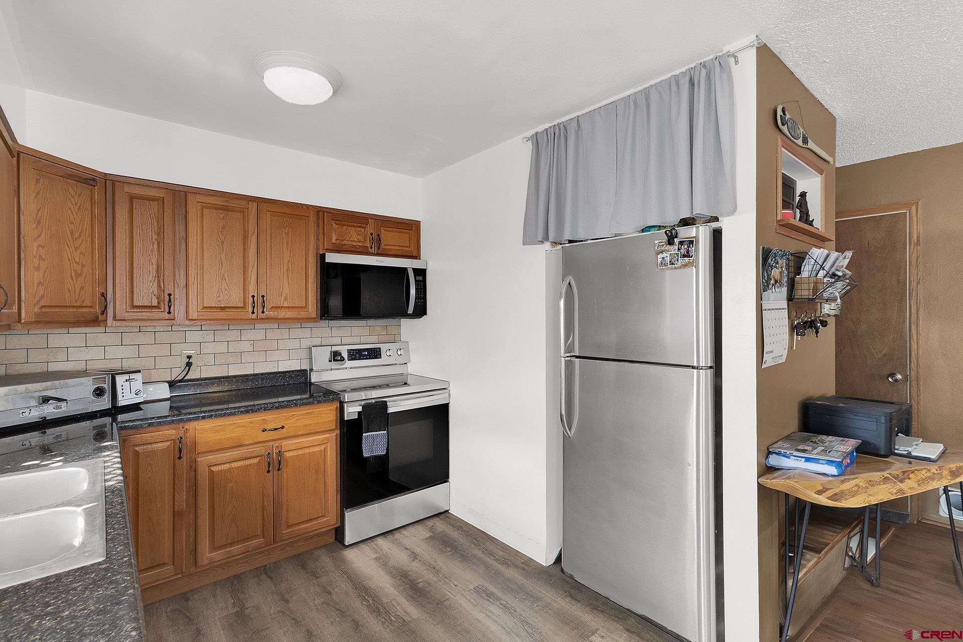 1011 Ray Avenue Delta, CO 81416 - Photo 10 of 26 a kitchen with stainless steel appliances a refrigerator stove microwave and sink