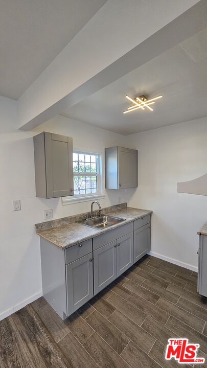 a large kitchen with granite countertop a sink and dishwasher with wooden floor