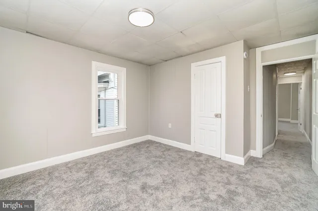 an empty room with windows and closet