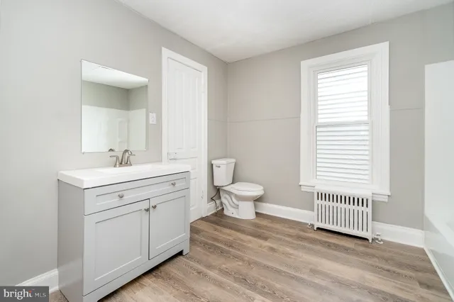a spacious bathroom with a sink a toilet and a window