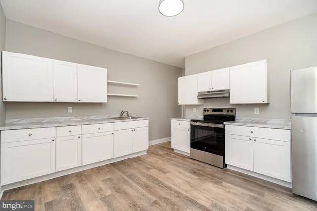 a kitchen with granite countertop white cabinets and stainless steel appliances