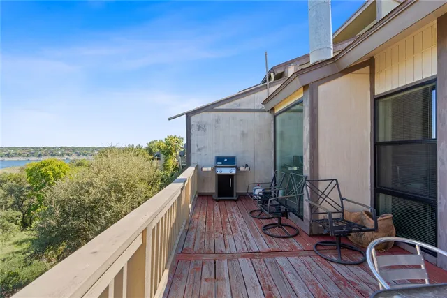 a view of a balcony with chairs and wooden floor