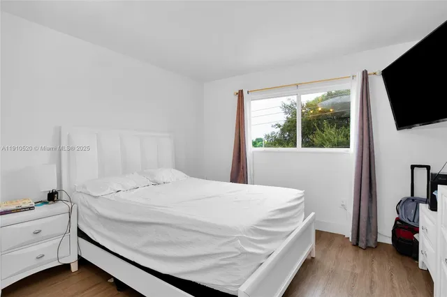 a bed sitting in a bedroom next to a window