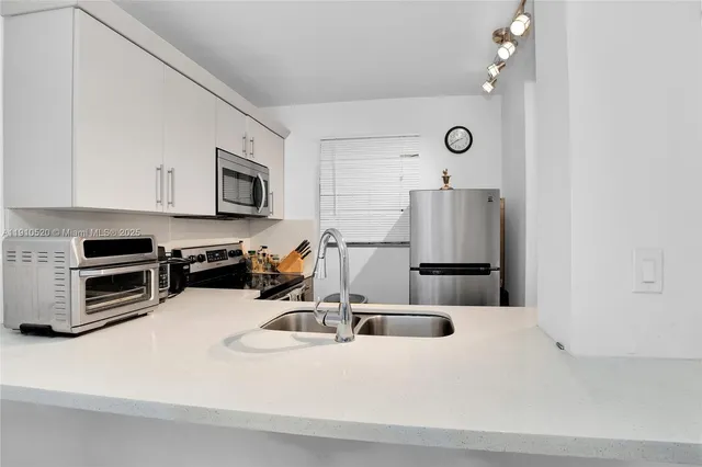 a kitchen with stainless steel appliances a sink a stove and cabinets