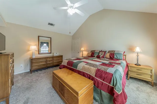 a bedroom with a bed closet and a flat tv screen