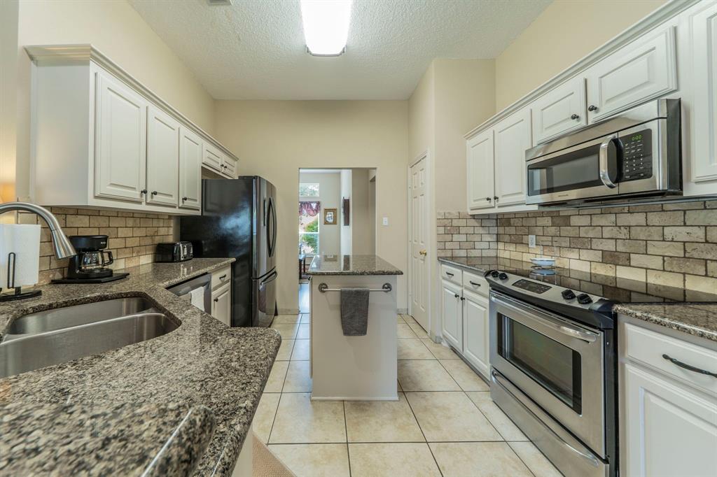 1013 Short Line Boulevard Midlothian, TX 76065 - Photo 5 of 26 a kitchen with stainless steel appliances granite countertop a stove a sink and a microwave