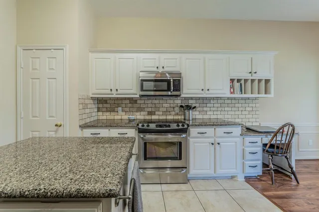 a kitchen with stainless steel appliances granite countertop a stove and cabinets