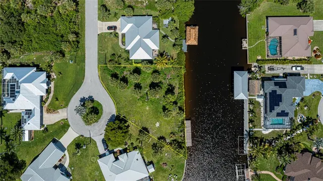 an aerial view of a house with a yard and lake view