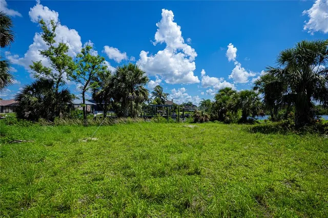 a view of a lake with lawn chairs and a fire pit