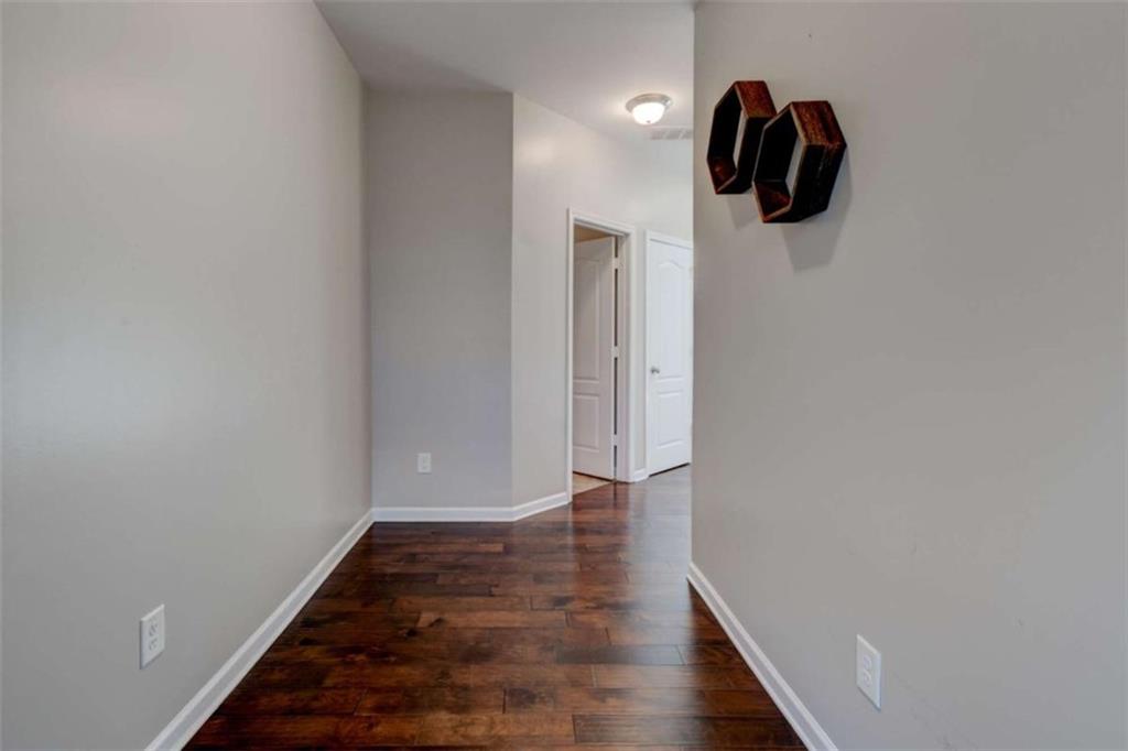 7601 Summer Berry Lane Lithonia, GA 30038 - Photo 4 of 34 a view of a hallway with wooden floor and a bathroom