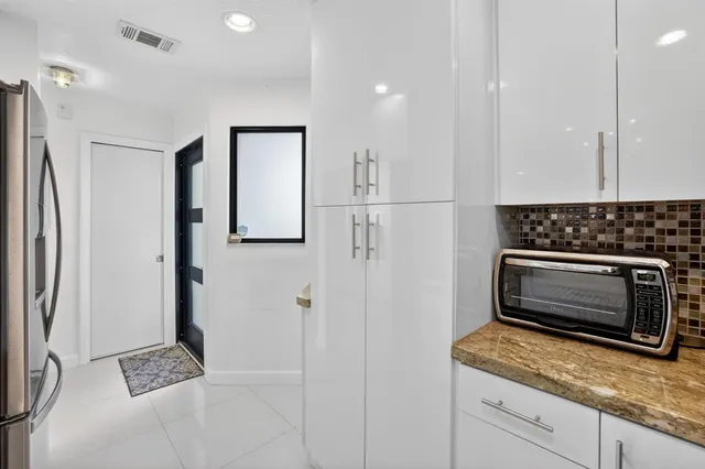 a bedroom with a large bed a flat tv screen and a large window with the outer view