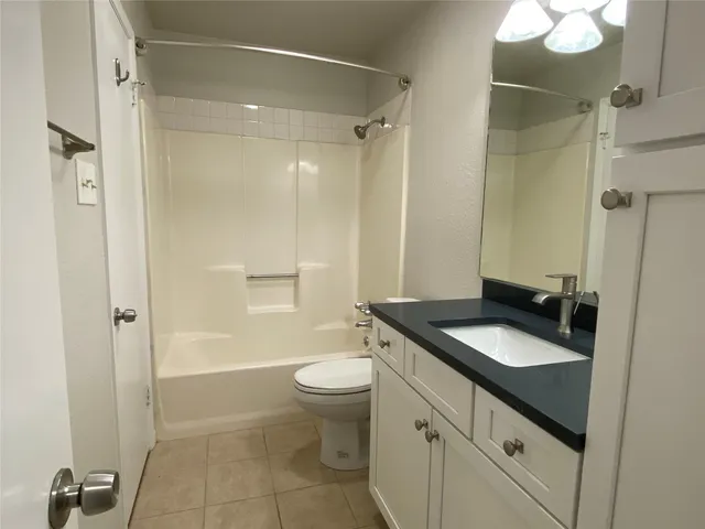 a bathroom with a granite countertop sink toilet mirror and shower