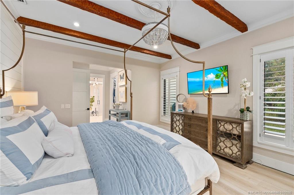 12038 Riverbend Road Port St. Lucie, FL 34984 - Photo 46 of 86 a bedroom with a bed a dresser and potted plants with the wooden floor