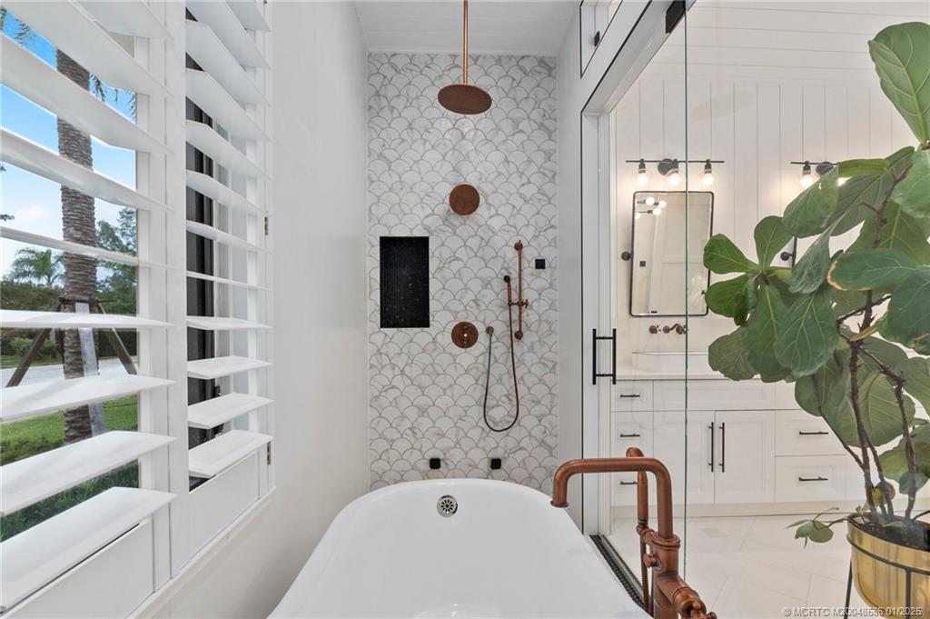 12038 Riverbend Road Port St. Lucie, FL 34984 - Photo 49 of 86 a bathroom with a tub and a shower