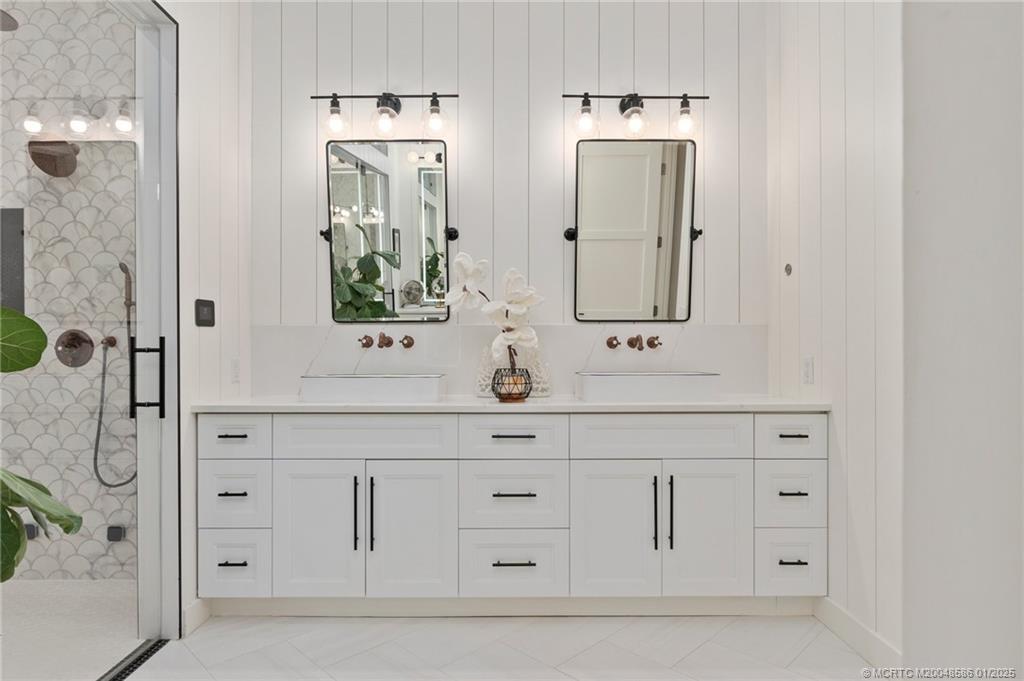 12038 Riverbend Road Port St. Lucie, FL 34984 - Photo 53 of 86 a bathroom with double vanity sink a mirror and shower