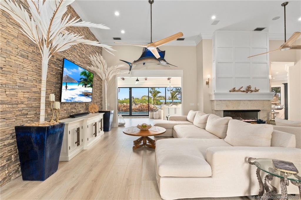 12038 Riverbend Road Port St. Lucie, FL 34984 - Photo 80 of 86 a living room with furniture a wooden floor and a fireplace